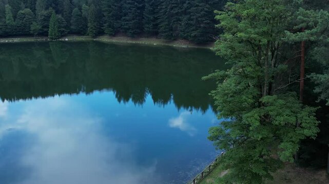 Aerial Scenic view Meugliano Lake in Val di Chy or Valchiusella, near Brosso town, Ivrea, Piedmont, Italy, Morainic Amphitheatre geological formation area, slow motion drone descend
