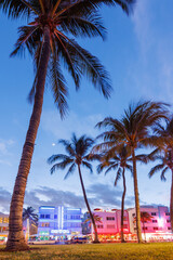 Colorful Art Deco hotels on Ocean Drive in Miami Beach glow under the warm hues of a vibrant sunset