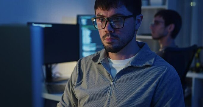 Team adult male freelance developer work late typing write prompt AI bot app program nomad terminal code at office night. Artificial intelligence dashboard, robotics, user interface, machine learning.