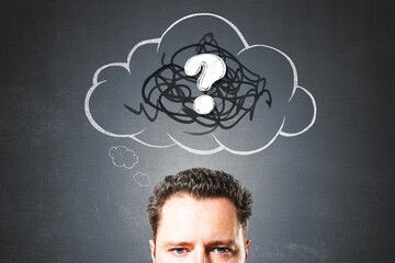 Confused businessman with scribble cloud and question mark symbol above head on dark background representing curiosity and problem-solving concept.