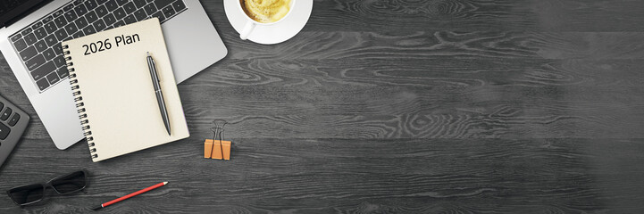 Top view of modern office desk setup with 2026 planner, laptop, coffee cup, and accessories on dark wooden background with copy space on right side. 3D Rendering