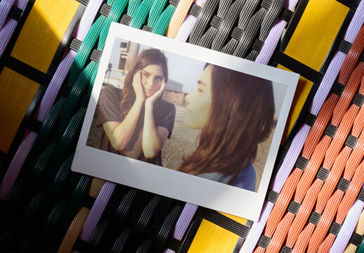 Blank instant photo mockup placed on colorful mat.