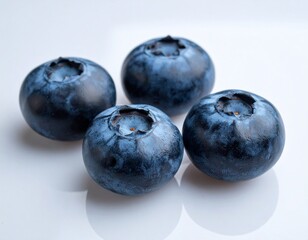 Obraz premium Three blueberries on matte ceramic surface, arranged diagonally