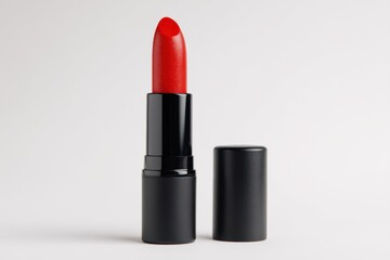 Red lipstick with open cap on white