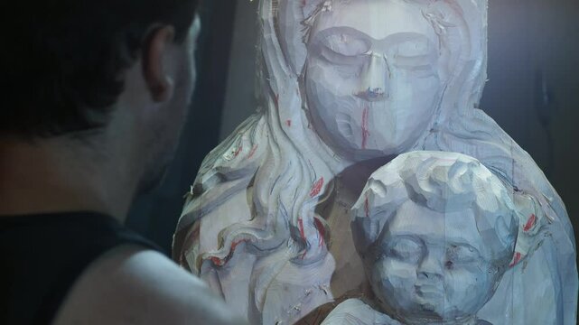 Skilled strong caucasian sculptor carving wooden virgin mary religious statue with mallet and chisel in workshop, showcasing creativity and craftsmanship in close up shot, slow motion