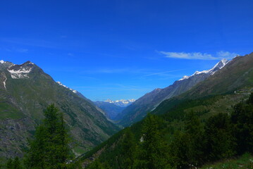 mountain landscape with snow-capped peaks and crystal clear blue sky in summer, Switzerland