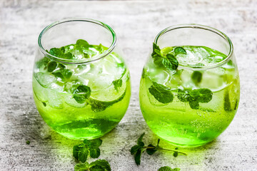 some mojito drinks with lime and mint leaves