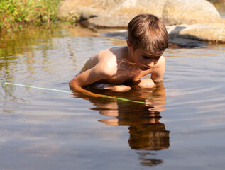 Young boy exploring nature in a stream
