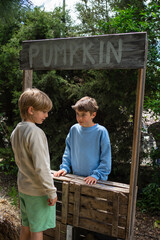 Children selling pumpkins at outdoor market stall in autumn