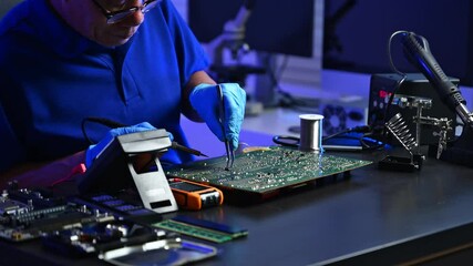 Closeup of technician testing a computer motherboard using tools and gloves. IT services, hardware diagnostics, and tech industry visuals.