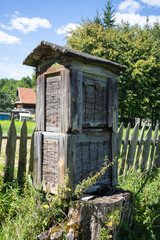 A wooden structure with a roof sits in a field