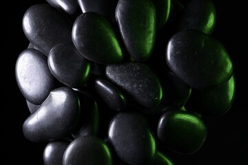 Black natural stones with dramatic lighting showing texture and reflections