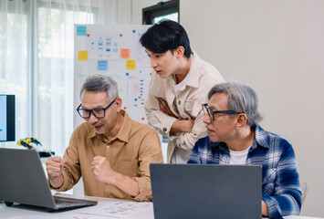 Senior developer team celebrates success in software collaboration and coding at a modern computer workstation