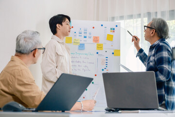 senior programmer bootcamlp,Asian young instructor guides senior learners through a programming on...