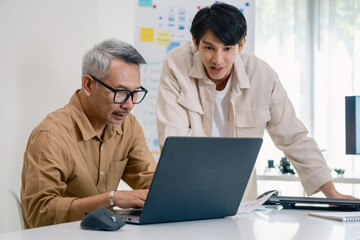 Obraz premium Asian Instructor Teaching Senior in Software Programming and Training Collaboration