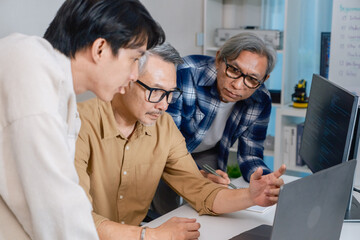 Team of developers collaborating in brainstorming and coding project at office workspace