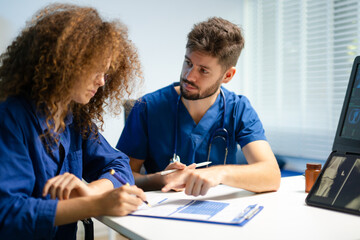 Naklejka premium Doctor guides female patient to complete medical registration form. Concept of healthcare paperwork, consent,
