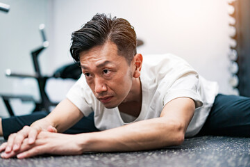 ジムでストレッチ運動をする男性