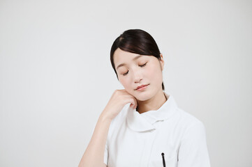 悩む白衣の女性