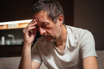 Failure and disappointment, low key portrait of mature adult male sulking