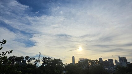 Fototapeta premium City skyline at sunrise with scattered clouds