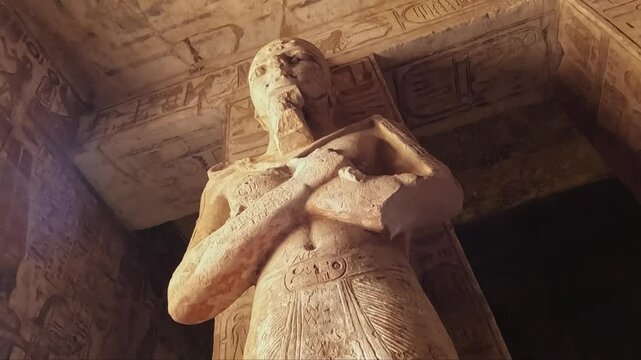 Interior view of the Great Temple at Abu Simbel, featuring colossal statues of Pharaoh Ramses II. The stone carvings and hieroglyphics on the walls.