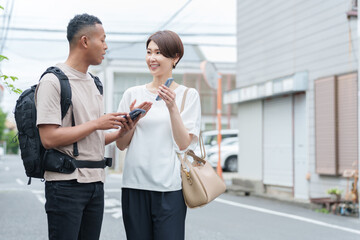 スマホ翻訳アプリで外国人に道案内する女性