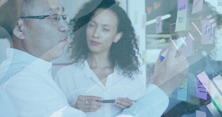 Image of digital infographic interface over multiracial coworkers discussing and writing notes