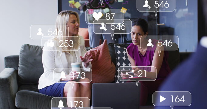 Image of social media icons and numbers over diverse businesswomen