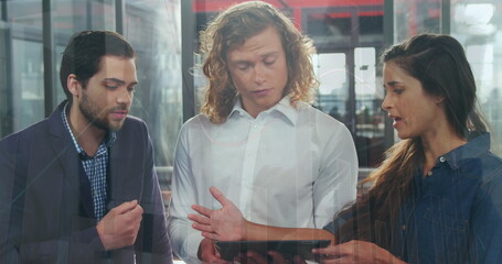 Image of data processing over diverse colleagues discussing over digital tablet at office