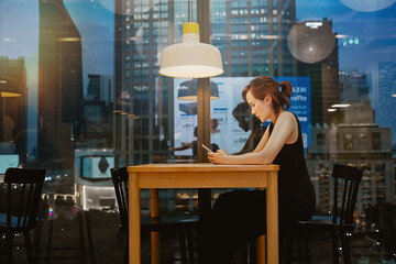 Lonely young busy Asian business woman leader holding cellphone device.