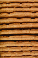 A stack of rectangular, light brown biscuits with ridged edges