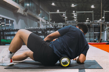 A young Asian boy with a well-defined athletic physique is captured on an athletic oval, likely within a gym