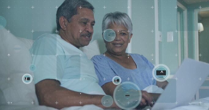 Image of 6g over senior couple using laptop in bed - Powered by Adobe
