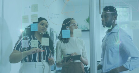 Image of flared light over multiracial coworkers brainstorming ideas over adhesive notes on wall