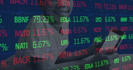 Image of stock market over african american boy using tablet