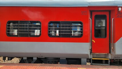 Windows of a sleeper class coach of a railway train at a station in north India.