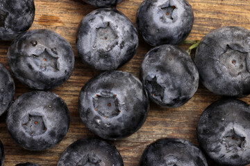Fototapeta premium Fresh ripe whole blueberries on rustic wood background blue berry