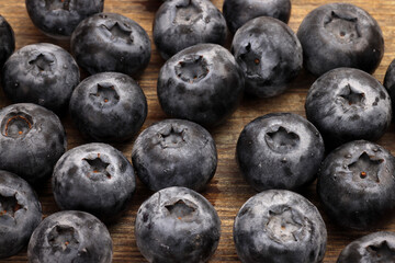 Fresh ripe whole blueberries on rustic wood background blue berry