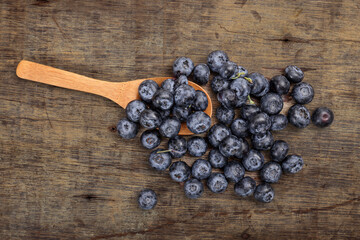 Fresh ripe whole blueberries on rustic wood background wooden spoon blue berry