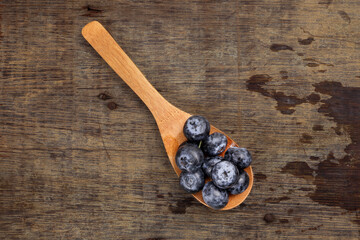 Fresh ripe whole blueberries on rustic wood background wooden spoon blue berry