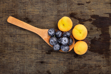 Fresh ripe whole blueberries apricot on rustic wood background wooden spoon blue berry