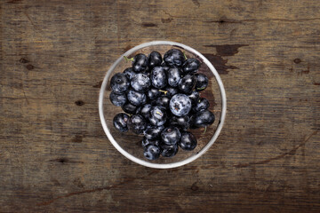 Fresh ripe whole blueberries on rustic wood background wooden in glass bowl blue berry