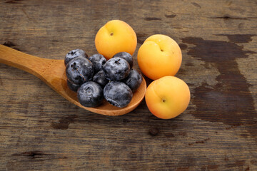 Fresh ripe whole blueberries apricot on rustic wood background wooden spoon blue berry