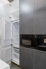 stylish built-in kitchen with gray facades. Built-in kitchen appliances. upper cabinets with gray...