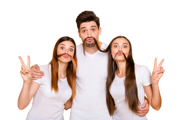 Portrait of adorable guys with long hair lips pouted plump making v-signs fooling wearing white t-shirt isolated over yellow background