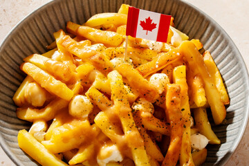 Traditional Canadian poutine with fries, cheese curds, and gravy, decorated with Canadian flag.