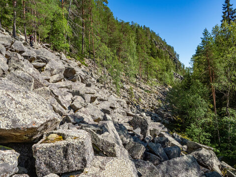 Large rocks and steep cliffs with trees growing on them on the shore of Lake Pizanets in Karelia in northwestern Russia