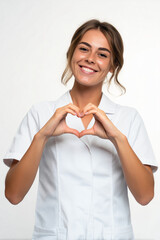  an half-body slightly fat smiling caucasian female medical staff in her late twenties, making the heart sign with both hands and wearing a white medical staff outfit against a white background. 