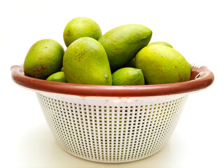 Fresh green mango fruit in a basket isolated on white background, tropical fruit, unripe mangoes for pickle